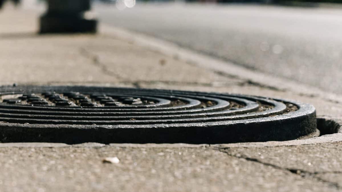 Close-up of a cast iron manhole cover embedded in pavement
